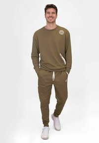 Olivgrüner Hoodie und passende Jogginghose, ausgestattet mit einem Logo auf der Brust, einer Reißverschlusstasche und einem verstellbaren Kordelzugbund.