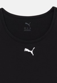 Μαύρο μπλουζάκι με λαιμόκοψη για κουτάβι, με λευκό λογότυπο Puma στο κέντρο κάτω από το λαιμό και ένδειξη μεγεθών τυπωμένη εσωτερικά.