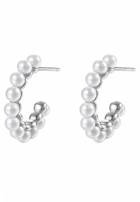 Boucles d'oreilles en argent en forme de cerceau, ornées d'une rangée de perles blanches sphériques et dotées d'une finition métallique polie, conçues pour créer une forme circulaire.