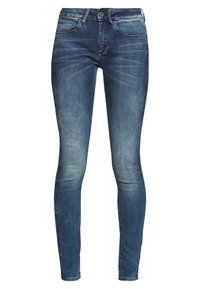 Tmavě modré skinny džínsy s vybledlým odstínem, pěti kapsami, zapín�áním na knoflík a zip a kontrastním prošíváním podél švů.