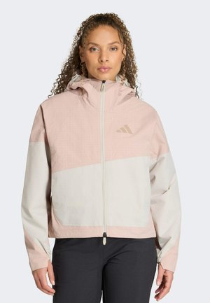 Veste légère à fermeture éclair avec un design bicolore rose et blanc, capuche, cintrage à la taille, et tissu texturé à motif quadrillé.