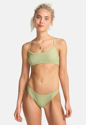 Bikini verde chiaro con texture a coste, caratterizzato da spalline sottili nella parte superiore e una parte inferiore a vita bassa. Design minimalista con colore abbinato in tutto.