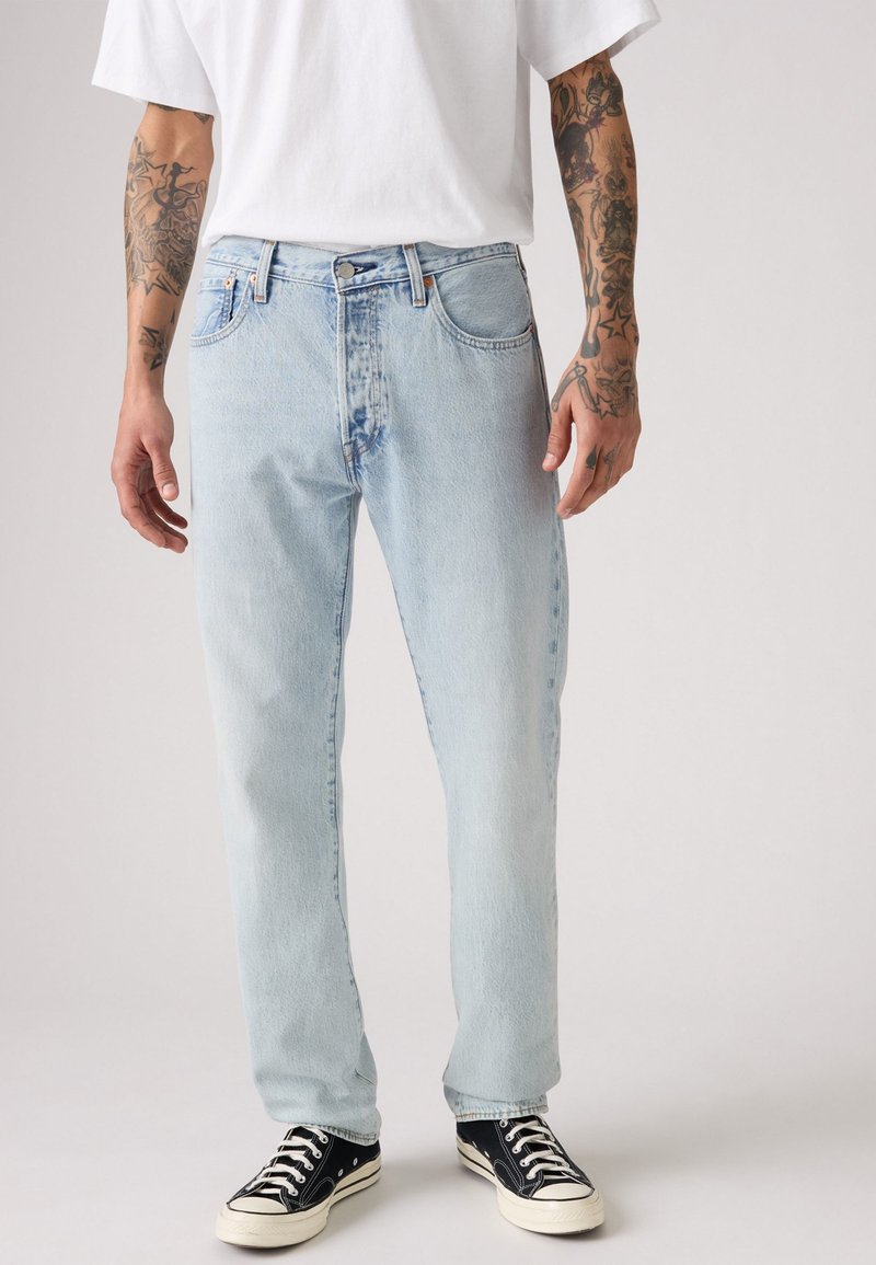 Jeans in denim blu chiaro con taglio dritto, design a cinque tasche e leggero effetto sbiadito. Abbinati a sneakers nere.