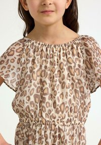 Luipaardprint jurk met korte, vloeiende mouwen, elastische tailleband en een zachte, lichte stof in beige en bruintinten.