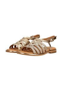 Sandalias planas con múltiples tiras tejidas en dorado metálico, punta abierta y cierres de hebilla en el tobillo sobre suelas color canela.