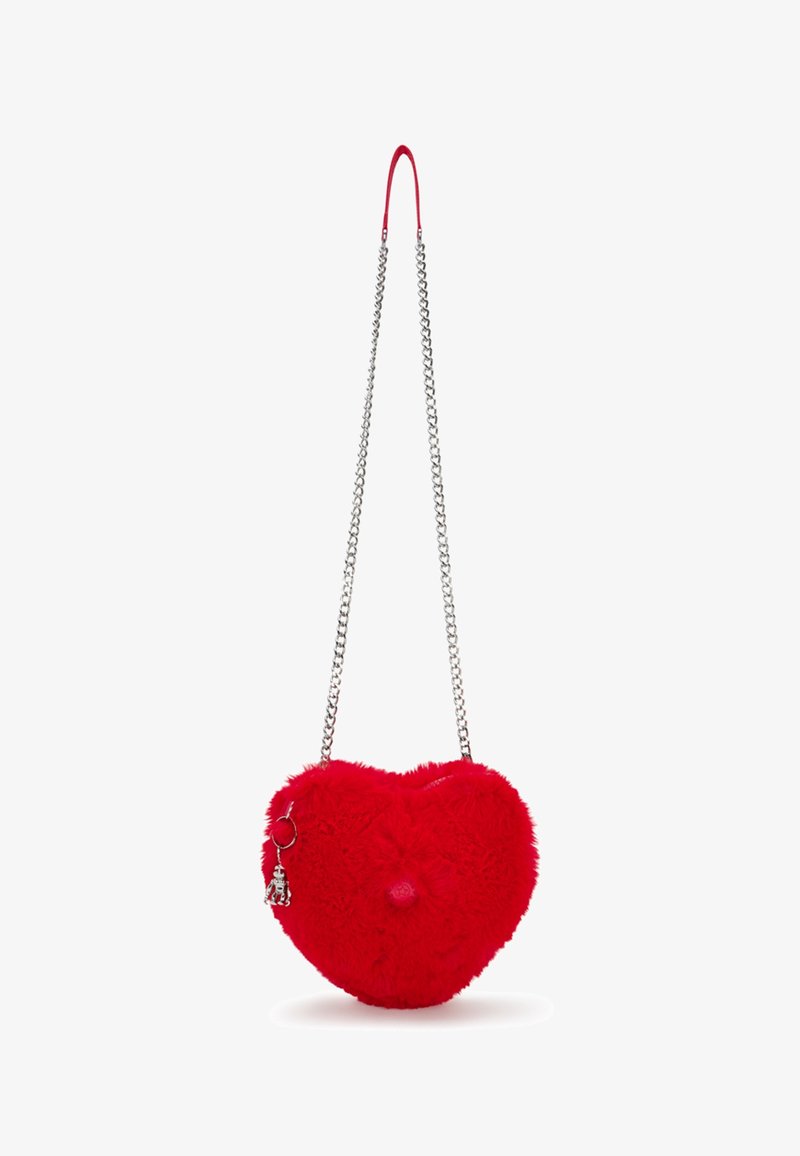 Sac à main rouge en forme de cœur avec fourrure, bandoulière en chaîne argentée et petit porte-clés robot attaché.