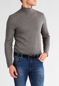 Grå høyhalset genser med lange ermer, laget av mykt strikkemateriale, kombinert med blå jeans og et svart belte. Enkelt design uten mønstre.