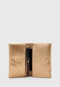 Portafoglio in pelle bronzo con una superficie liscia, dotato di chiusura superiore a zip e accenti triangolari sul davanti. Design compatto e rettangolare.