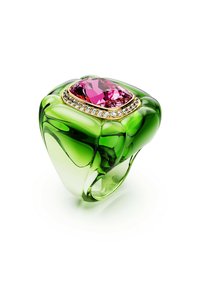 Grüner Ring mit einem großen rosa Edelstein, umgeben von kleinen klaren Steinen, der ein elegantes und modernes Design zeigt.