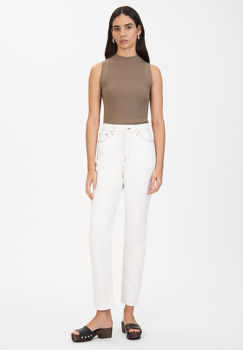 Top sin mangas de color marrón con relieve, jeans blancos de cintura alta, sandalias de plataforma negras con tacón grueso, diseño minimalista, textura suave.