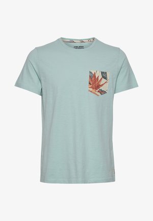 Világoskék pamut póló rövid ujjakkal, mintás mellzsebbel, földszínekben lévő levelekkel. Kerek nyakkivágás, laza fazon.