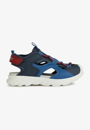 Chaussure en mesh bleu et marine avec des accents rouges, des lacets élastiques, et une semelle blanche texturée ; comprend des découpes pour la ventilation et la flexibilité.