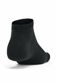 Schwarze Knöchelsocke mit ribbeliger Textur und einer sanft gerundeten Ferse. Mit elastischem Bündchen und dezentem Branding entlang der oberen Kante.