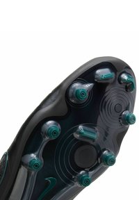 Suola di scarpa da calcio nera con sei tacchetti conici verdi e due dettagli circolari. Superficie liscia e testurizzata con un design elegante.