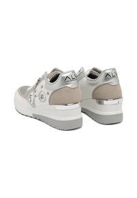 Sneakers chunky con una combinazione di colori bianco e beige. Presentano dettagli in suede, hardware metallico e una suola testurizzata con un tacco argento.