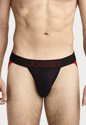 Männlicher Oberkörper, der einen schwarzen und roten Jockey-Sport-Jockstrap mit perforiertem Vorderbeutel und breitem Bund trägt.