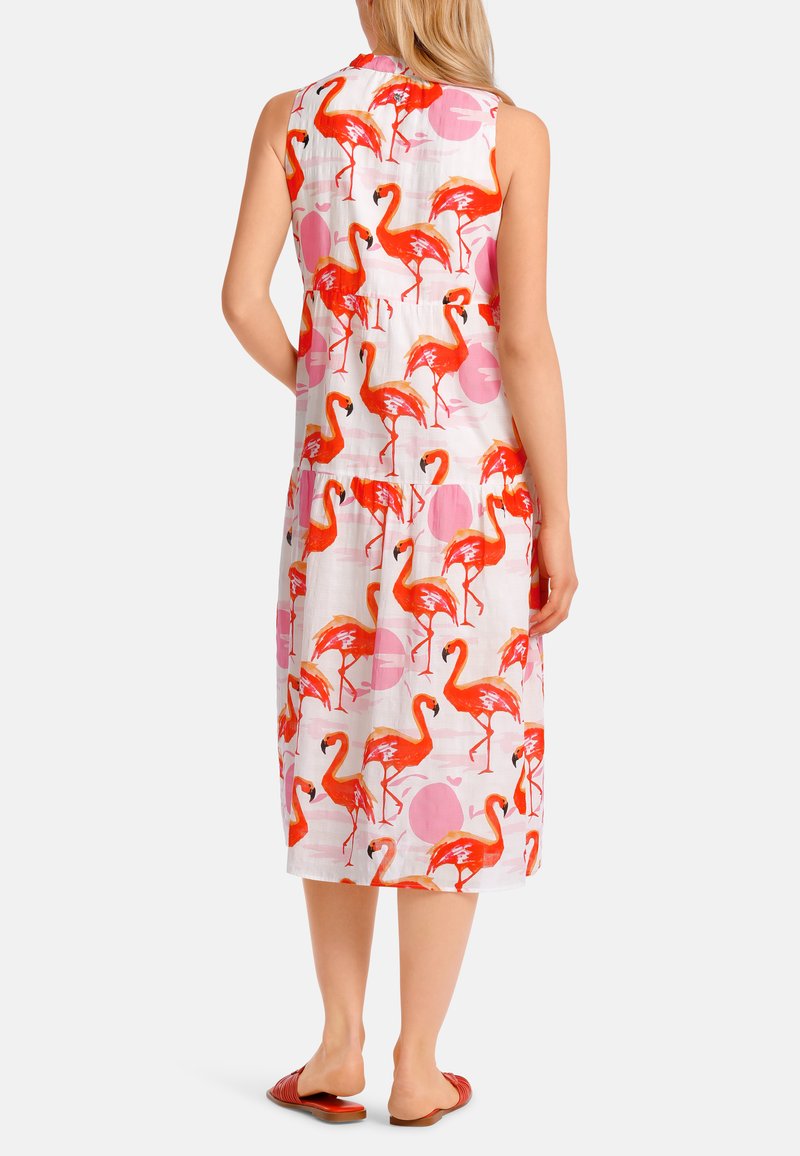 Ärmelloses weißes Kleid mit einem lebhaften Flamingo-Druck in Pink und Rot sowie kreisförmigen Akzenten. Hergestellt aus leichtem Stoff, knielange Länge.