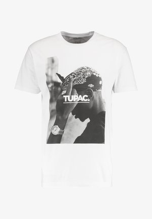 Bílá tričko s černobílým potiskem grafiky osoby s bandanou a hodinkami, s textem "TUPAC:" pod obrazem.