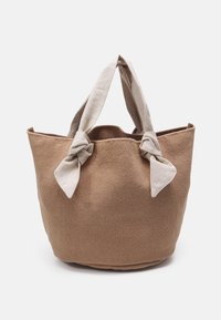 Sac fourre-tout tressé marron avec une surface texturée, équipé de deux anses en tissu beige nouées en haut. Conception à ouverture supérieure.