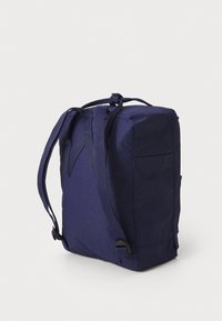 Mochila de tecido azul-marinho com duas alças ajustáveis, formato retangular, lados planos e um pequeno bolso exterior na parte de trás.