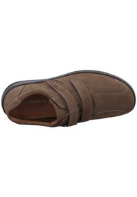 Brown suede shoe with double Velcro straps, padded collar, rounded toe, and contrasting white stitching on a flexible rubber sole.