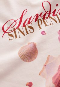 Tela blanca con texto en cursiva roja y letras doradas. Decorada con gráficos de conchas marinas rosas de diferentes tamaños y formas.