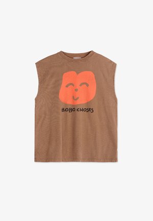Brown sleeveless shirt with a large orange smiling face logo. Features soft cotton fabric and a relaxed fit, with "BOBO CHOSES" printed below.