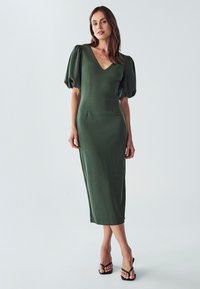 Grünes, figurbetontes Midikleid mit tiefem V-Ausschnitt und Puffärmeln. Glatte Textur, mit tailliertem Schnitt und reicht bis zur Mitte der Wade.