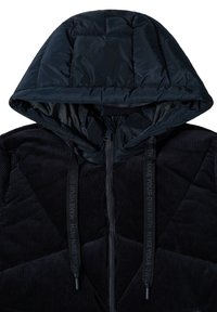 Veste en velours côtelé noir et doudoune matelassée avec capuche. Équipée d'une fermeture éclair sur le devant, de tissu texturé et de cordons de serrage réfléchissants avec texte imprimé.