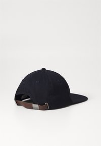 Navy cotton cap featuring a curved bill, adjustable leather strap with a metal buckle, and stitched eyelets for breathability.