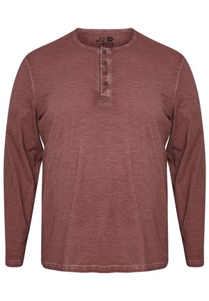 Langarm-Henley-Shirt in einem verblassten Rostton, mit Rundhalsausschnitt, fünf Knöpfen und einer lockeren Passform. Weicher, strukturierter Stoff.