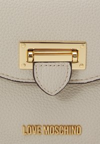 Borsa a tracolla in pelle grigia chiara con texture, dotata di hardware dorato, caratterizzata da un dettaglio con chiusura e accenti cuciti, etichettata "LOVE MOSCHINO" in oro.
