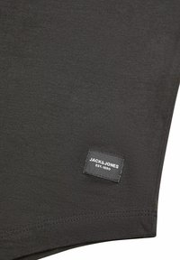 Zwarte katoenen t-shirt met een gestikt label waarop "JACK & JONES EST. 1990" staat aan de onderzijde, met een gladde textuur en eenvoudig ontwerp.