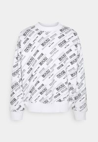 Vit sweatshirt med svart tryckt text och logotyper i ett diagonalt mönster. Har ribbad mudd och nederkant, vilket ger en avslappnad passform.