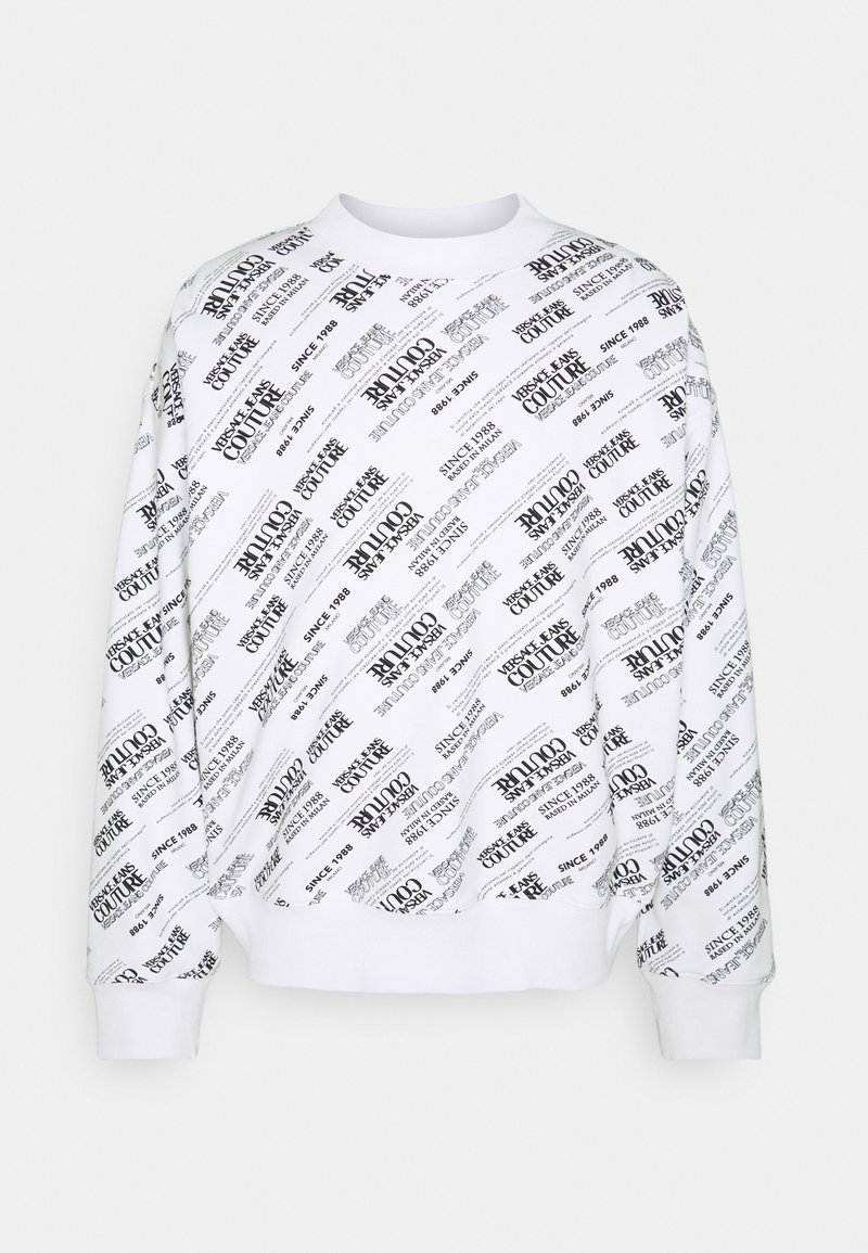 Vit sweatshirt med svart tryckt text och logotyper i ett diagonalt mönster. Har ribbad mudd och nederkant, vilket ger en avslappnad passform.