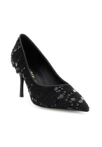 Scarpa nera con punta a punta e tacco alto, rivestita di paillettes nere lucide, su uno sfondo bianco.