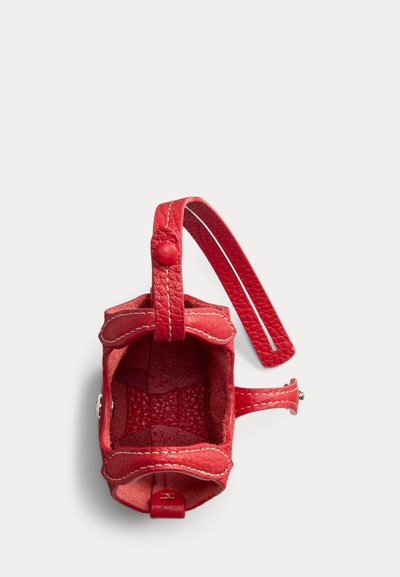 Lille rød læder møntpung med hvide syninger, åben top og enkelt håndledsrem fastgjort med en knap.