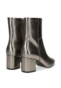 Metalické kotníkové boty s elegantním designem, vybavené čtvercovým blokovým podpatkem a zipovým zapínáním na zadní straně, odrážející světelné vzory.