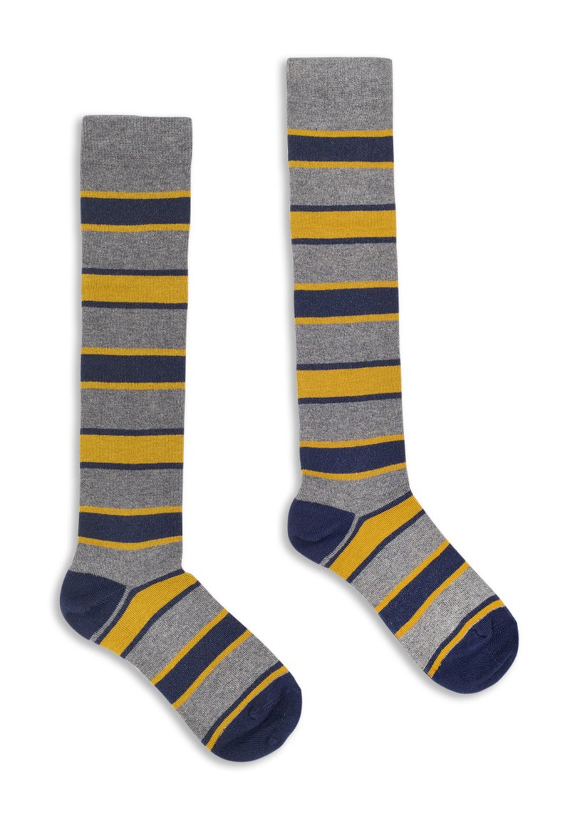 Une paire de chaussettes montant jusqu'au genou avec des rayures horizontales grises, bleu marine et jaunes, des talons et des orteils bleu marine, posée à plat sur un fond blanc.