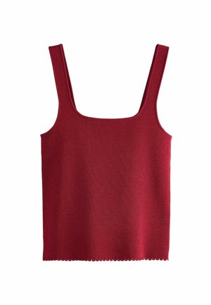 Punane ribaga ükstehase T-särk, millel on ruudukujuline kaelus ja laiad rihmad. Hem on kaunistatud sakiliste servadega. Valmistatud pehmest ja venivast kangast.