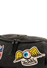 Borsa in tela nera con una texture liscia, dotata di cerniera metallica, toppe con design colorati, tra cui ali e un occhio, e branding.