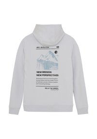 Sweat à capuche blanc avec une poche kangourou à l'avant, arborant un design graphique de montagnes et un texte dans le dos. Texture douce, coupe standard.