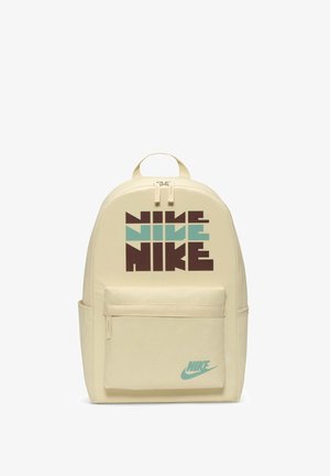 Beige rugzak met een gladde textuur, voorzien van een grote grafische afbeelding in bruine en teal tekst. Inclusief een voorvak en een merklogo.