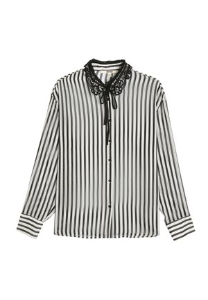 Blusa de rayas en blanco y negro con mangas largas, un collar con dobladillo de encaje y un lazo en la parte delantera. Presenta botones y detalles de rayas en contraste en los puños.