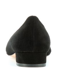 Scarpa bassa in suede nero con punta appuntita. Presenta una tomaia leggermente texturizzata e un piccolo tacco. La suola ha una leggera curvatura per un migliore adattamento.