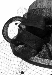 Black fascinator hat features a layered mesh design, a twisted ribbon accent, and a delicate netting attached, creating texture and dimension.