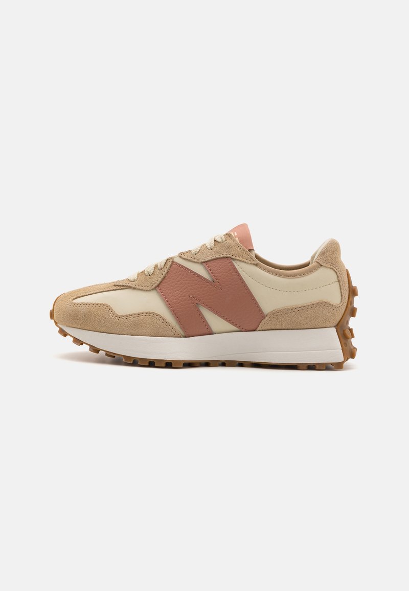 Baskets New Balance beige et rose clair avec tige en suède et cuir, semelle intermédiaire blanche et semelle extérieure en gomme texturée vues de profil.