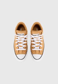 Barna vászon tornacipők fehér fűzővel, gumi orral és fekete díszítéssel. A nyelvén két címke található: 'Converse' és 'All Star'.