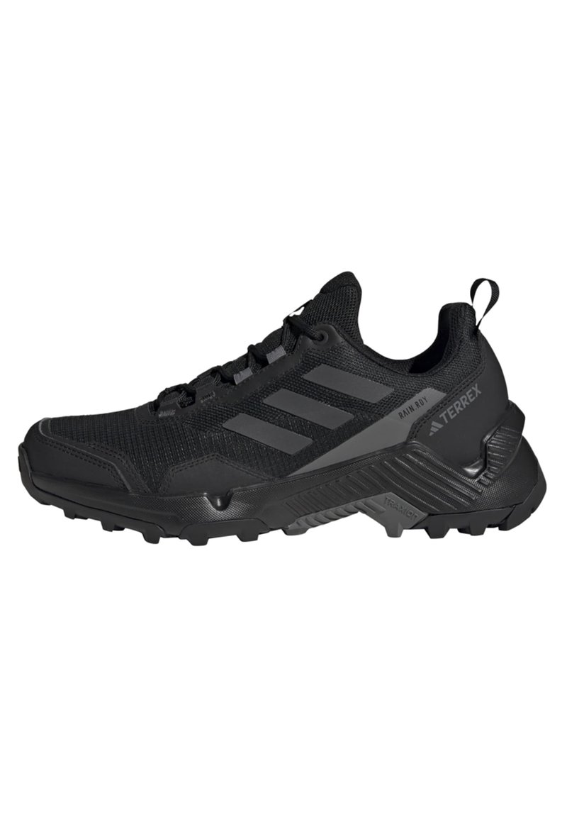 Chaussure de randonnée noire avec une tige en mesh texturé, un embout renforcé, un accent à trois rayures et une semelle robuste pour une traction optimale.