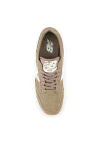 Zapatilla de color marrón claro con puntera perforada, cordones beige y logo blanco; cuenta con un upper de tejido texturizado y suela de goma.
